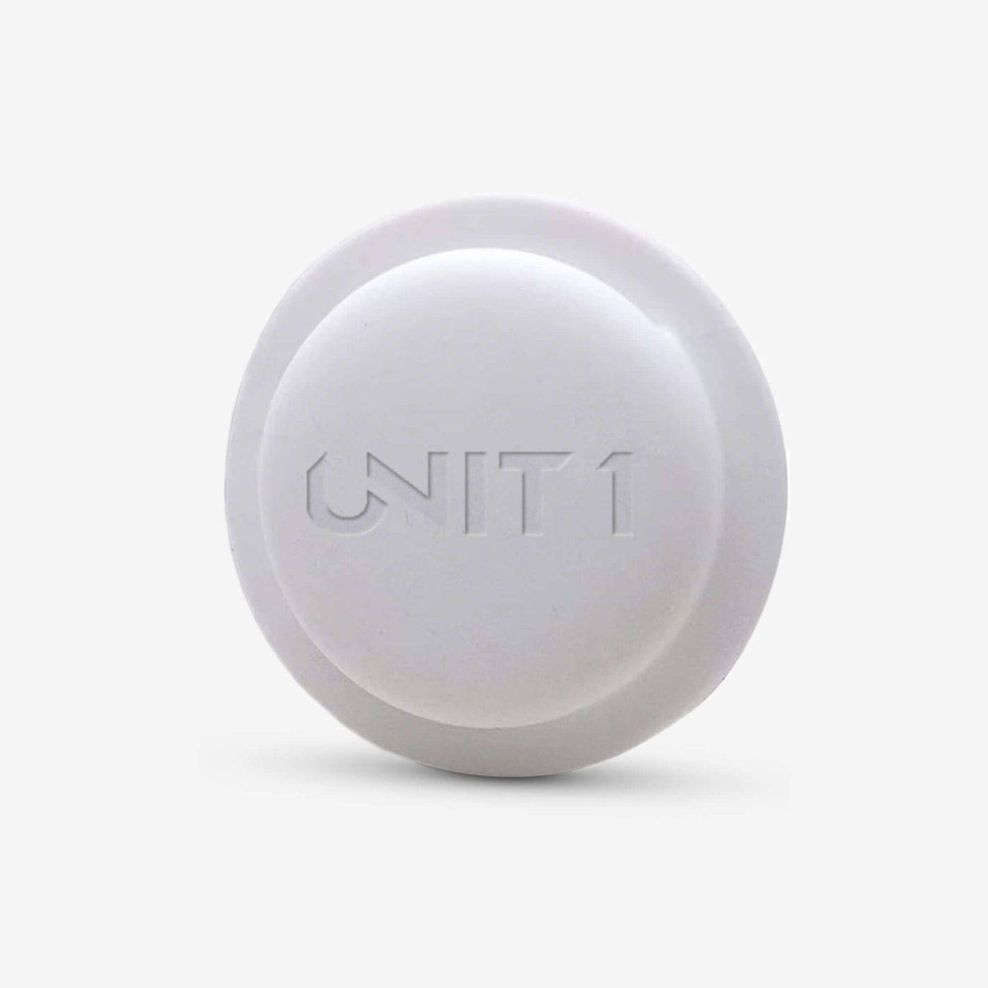 White round AirTag helmet holder with engraved UN1T 1 logo for secure attachment.