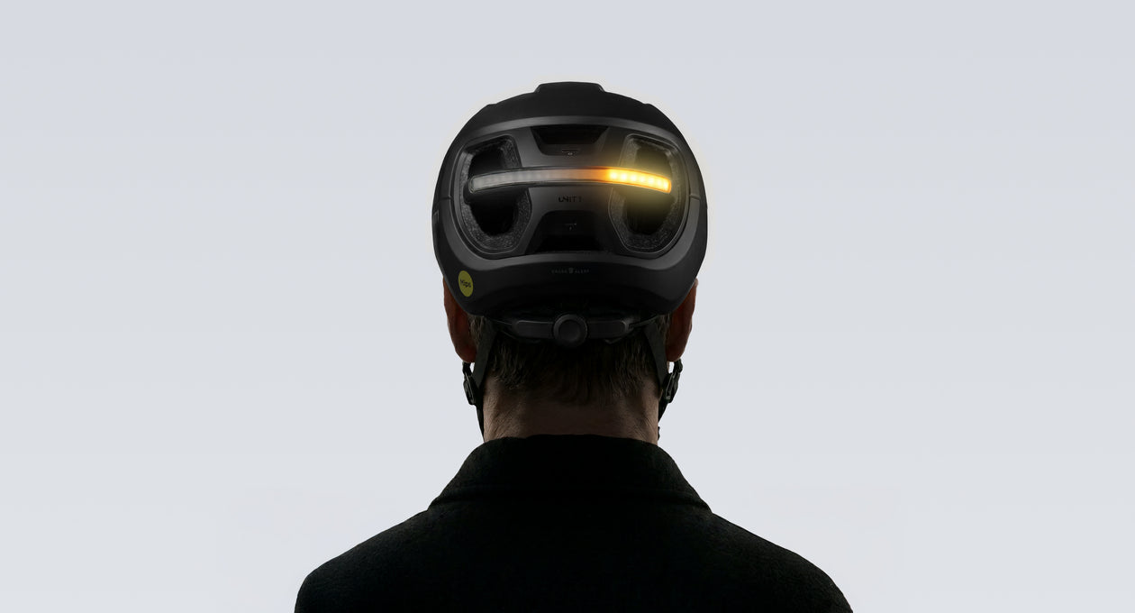 Rear view of UNIT 1 AURA helmet with amber turn signal flashing