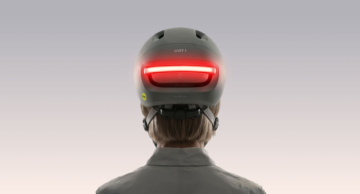 Achterkant van een motorrijder die een NEON-helm met een rode lichtbalk draagt