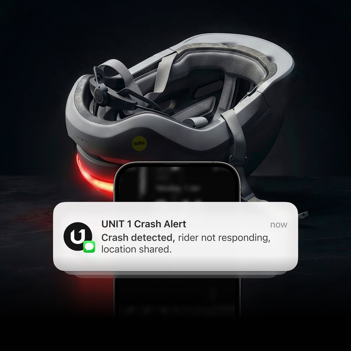 Casque AURA gris à côté d'un téléphone affichant une notification Crash Alert UNIT 1