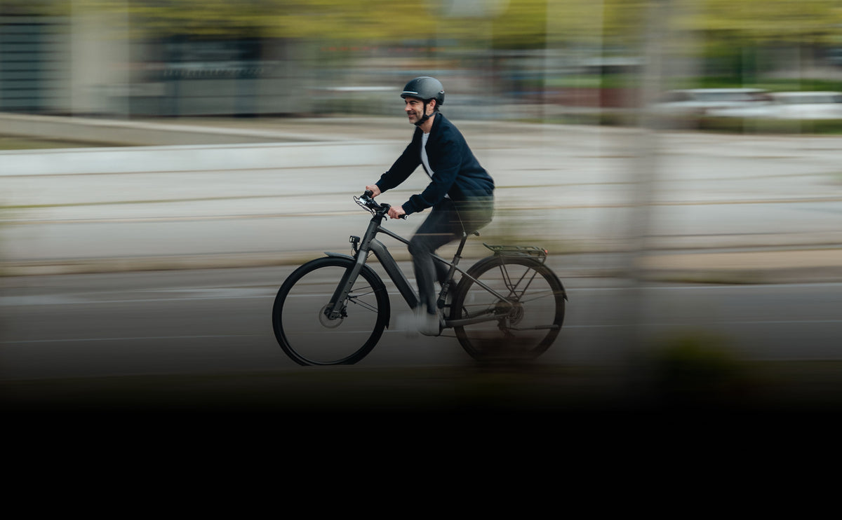 hombres que llevan un casco elegante mientras van en bicicleta 