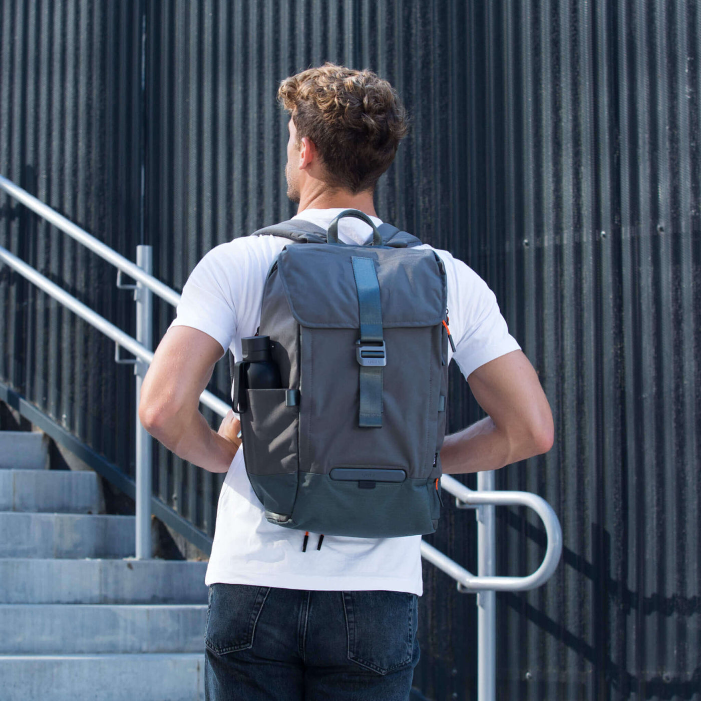 Homem comTORCH  UNIT 1 TORCH , na elegante Ashen Gray , e a garrafa UNIT 1 - Vista frontal