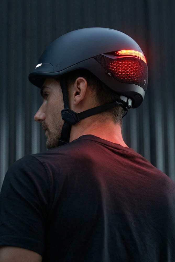 Cycliste portant un casque UNIT 1 noir équipé d'un feu arrière rouge clignotant