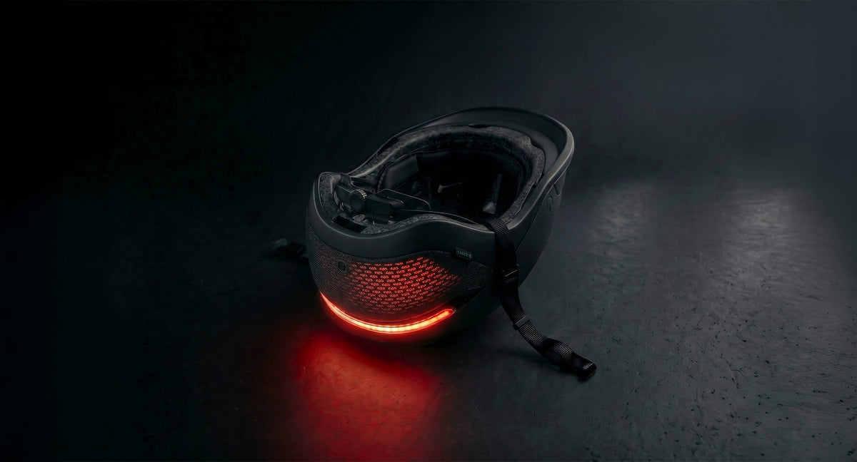 UNIT 1 : Der UNIT 1 -Smart-Helm liegt kopfüber, wobei das Rücklicht rot leuchtet