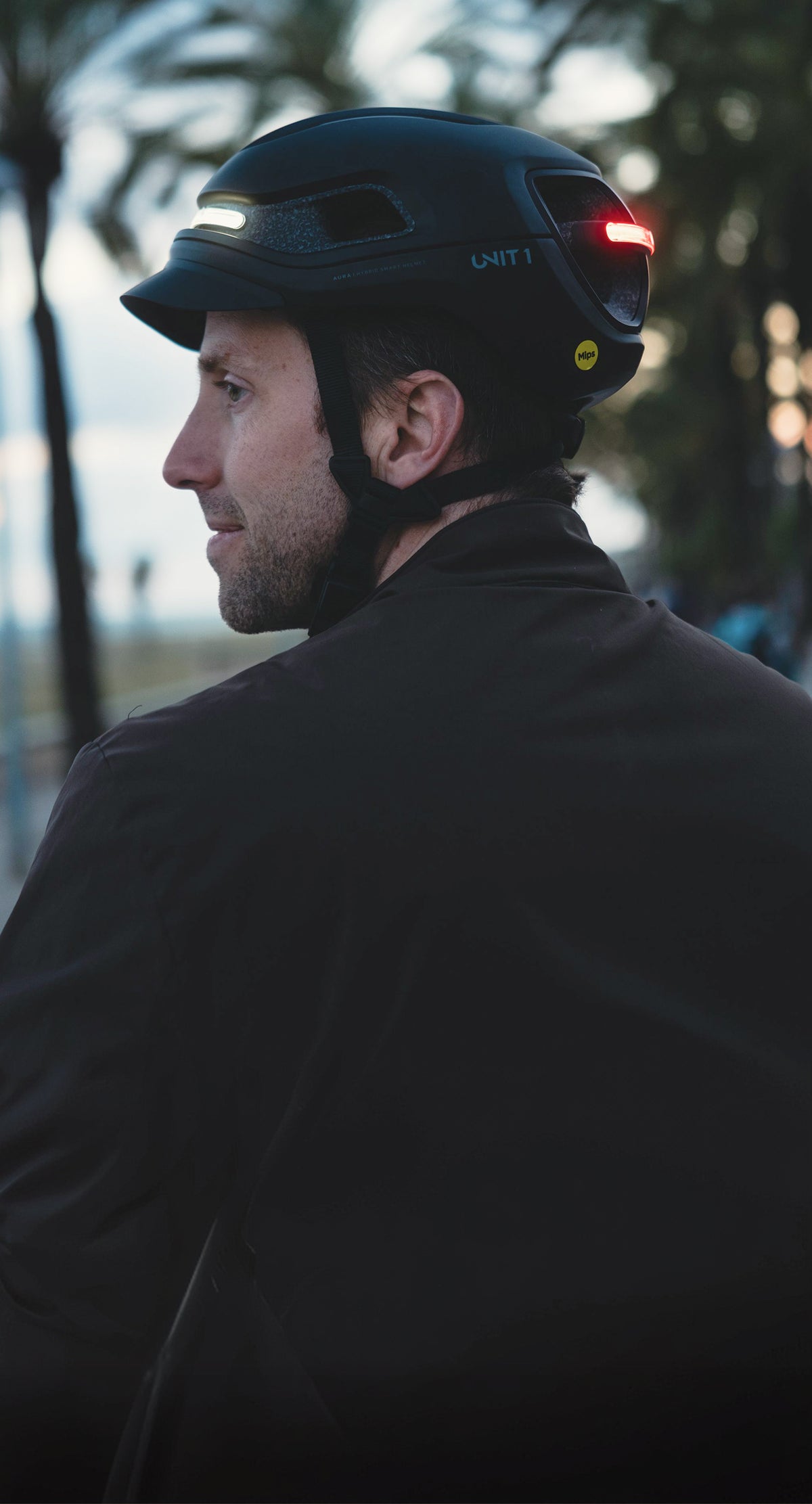 Rider wearing a UNIT 1 smart helmet with its front and rear lights on